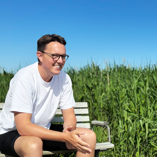 Casper Engholm på en bænk ved Roskilde Fjord.