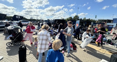 Billedet viser en masse mennesker, der kigger på genbrug på Holbæk Genbrugsplads til Genrbugets Dag 2024